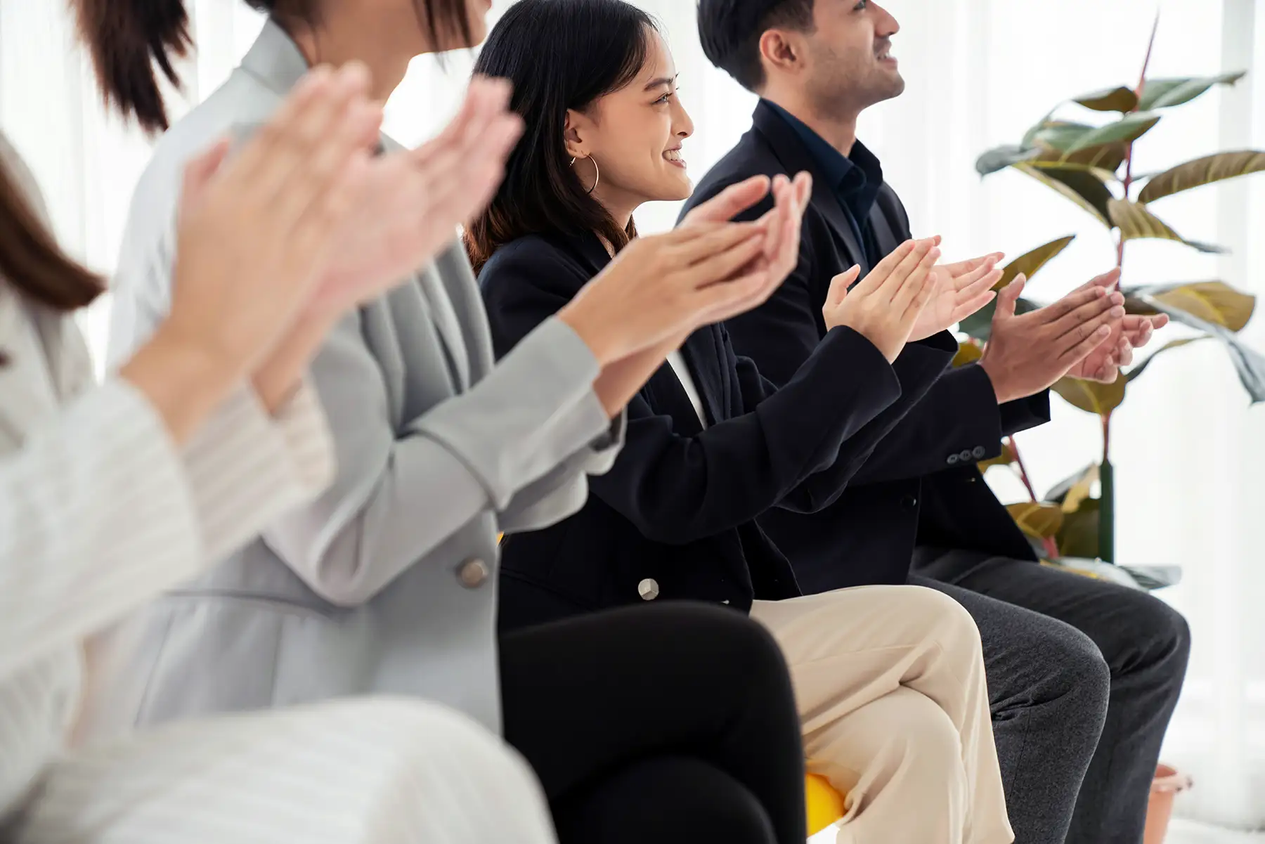 A small team of professionals clapping at a team building event at Millrace