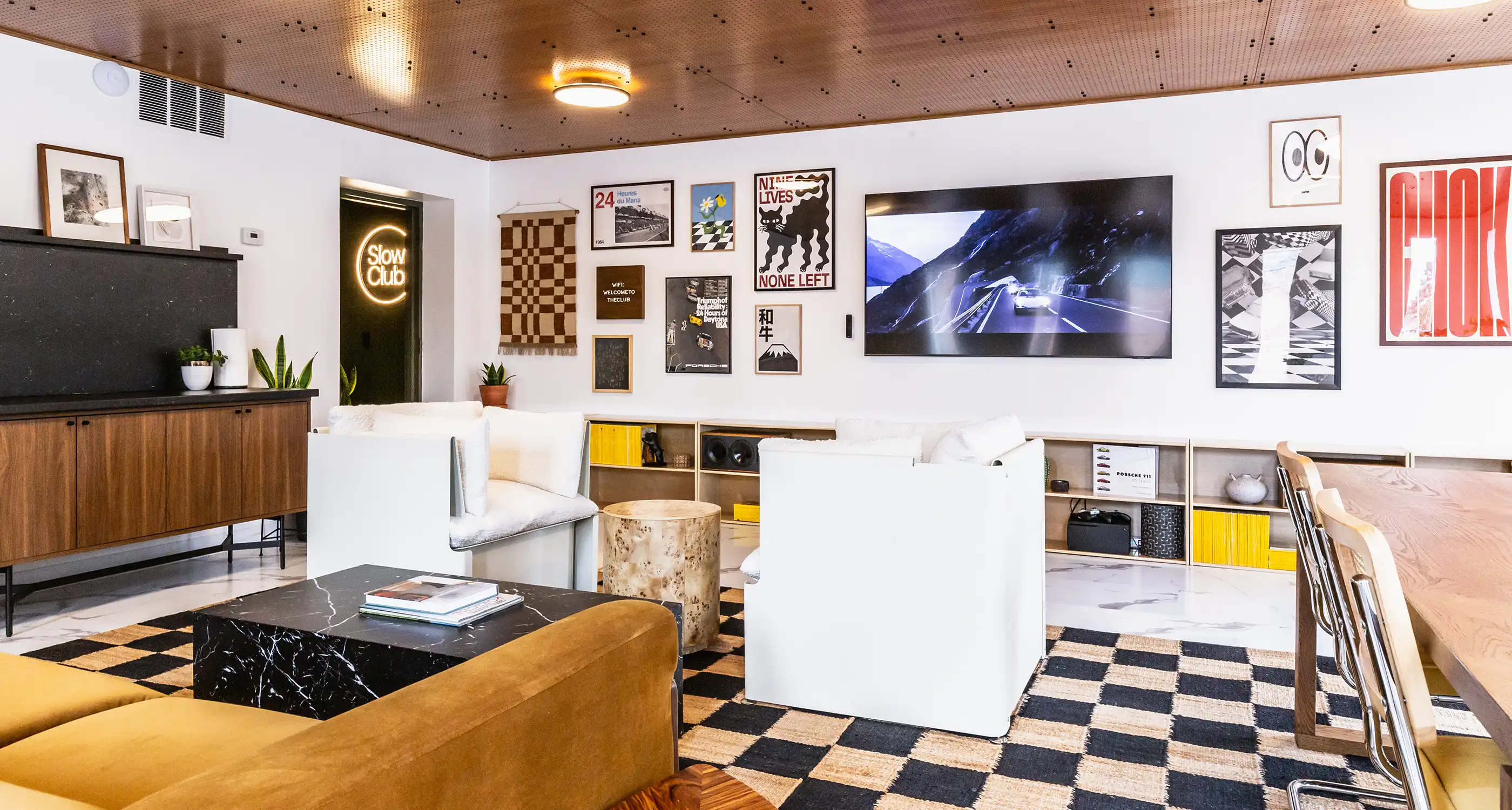 A corner of the Slow Club clubhouse with a vintage car and mid century furniture