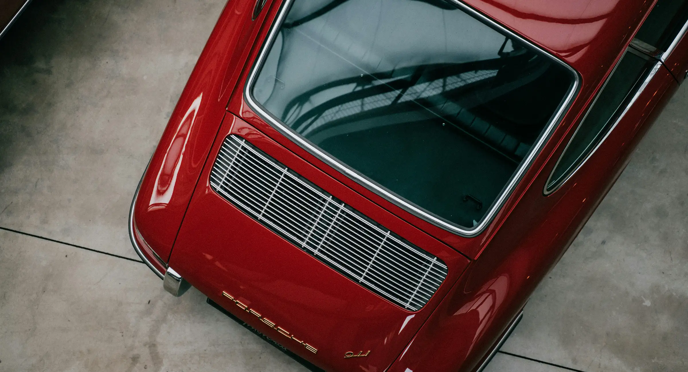 A birdseye view of the frunk of a vintage Porsche 911 on a concrete floor