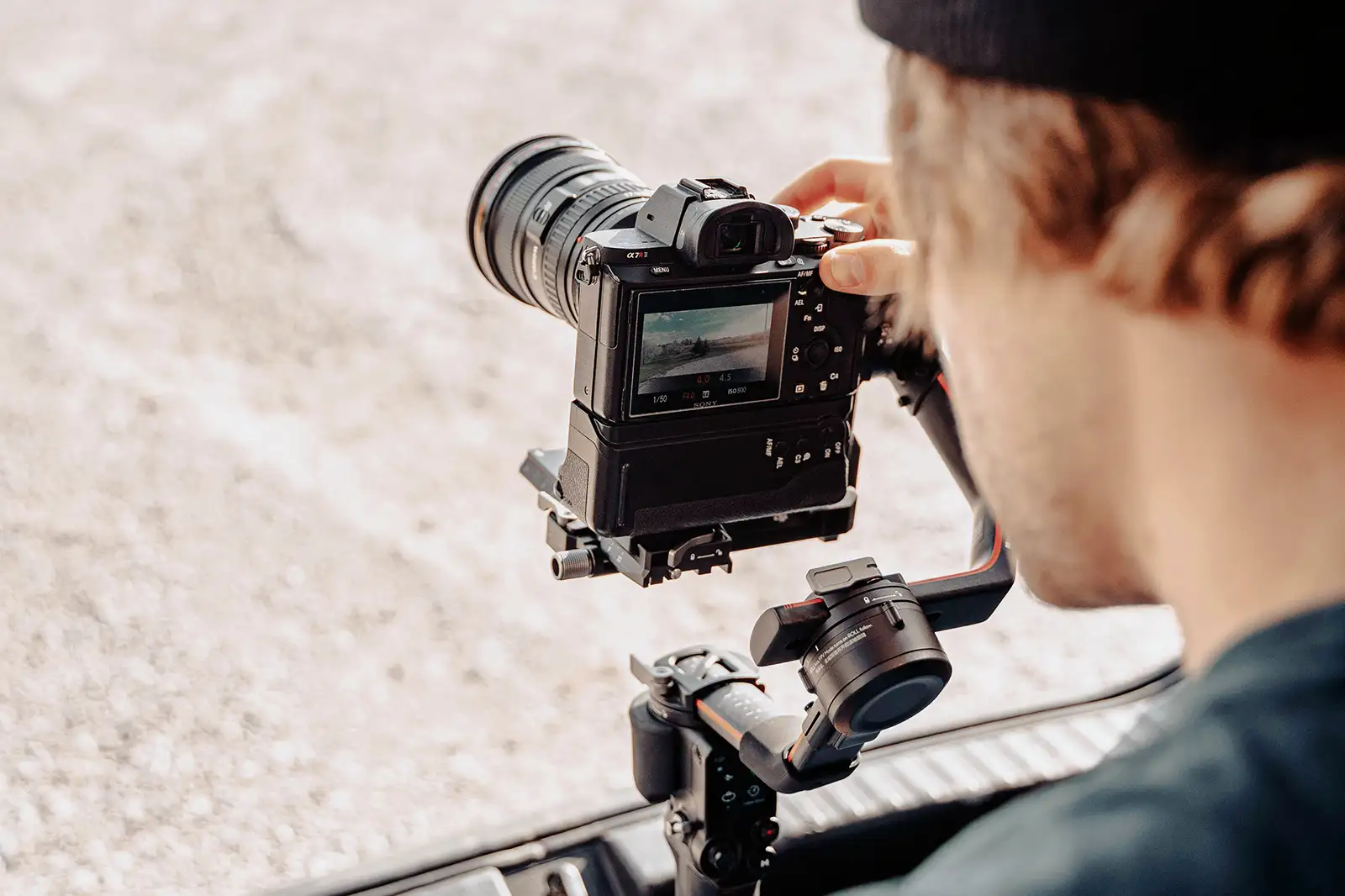 A photographer in a vehicle taking rolling shots of a car
