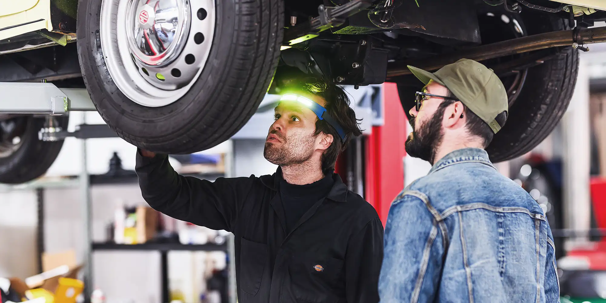 A mechanic inspecting suspension on a vintage Porsche 356