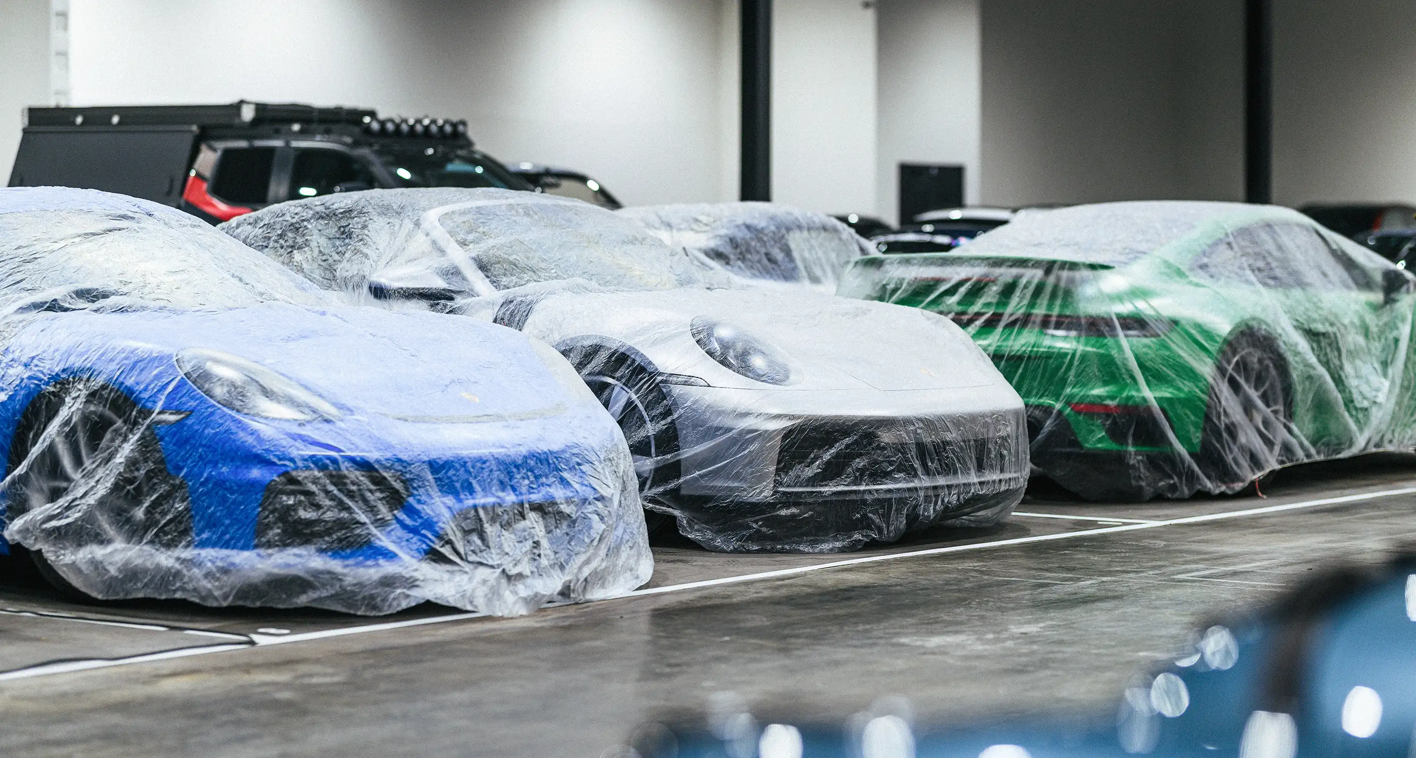 A Porsche GT3 and a McLaren staged in a storage facility