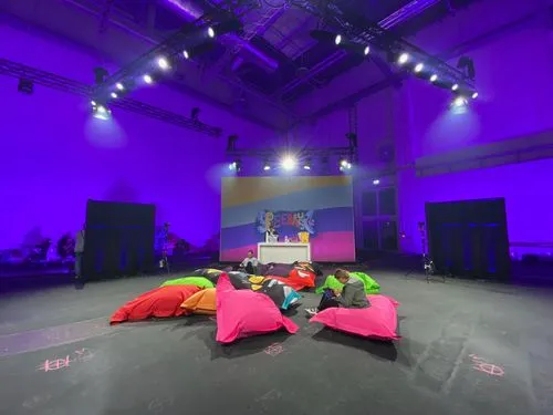 Spielesause 2020 in Köln sitzsäcke liegen auf dem boden der hintergrund ist blau eingefärbt und in der decke hängen lampen
