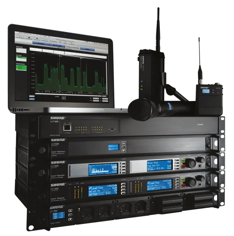 Audio equipment setup with a laptop, microphone, and several stacked electronic devices, likely for sound management.