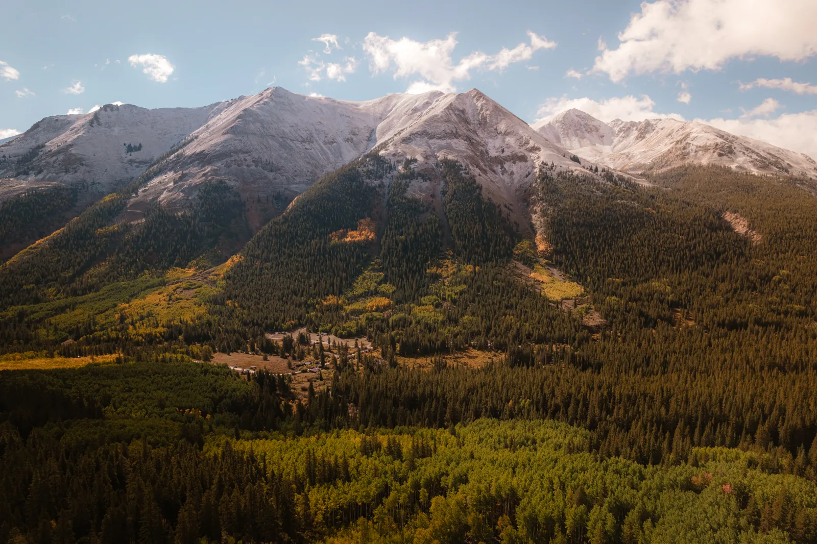 Snow-capped peaks above autumn aspens