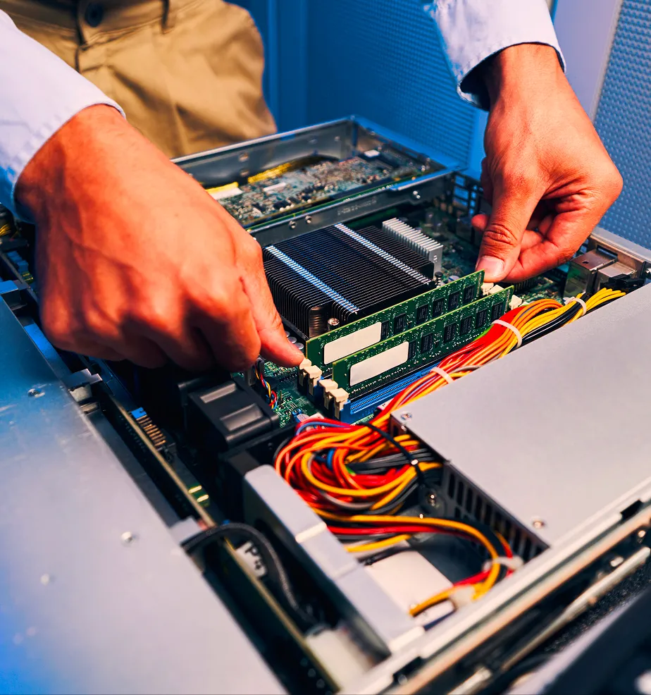 Technician installing or adjusting RAM memory modules inside a desktop computer.