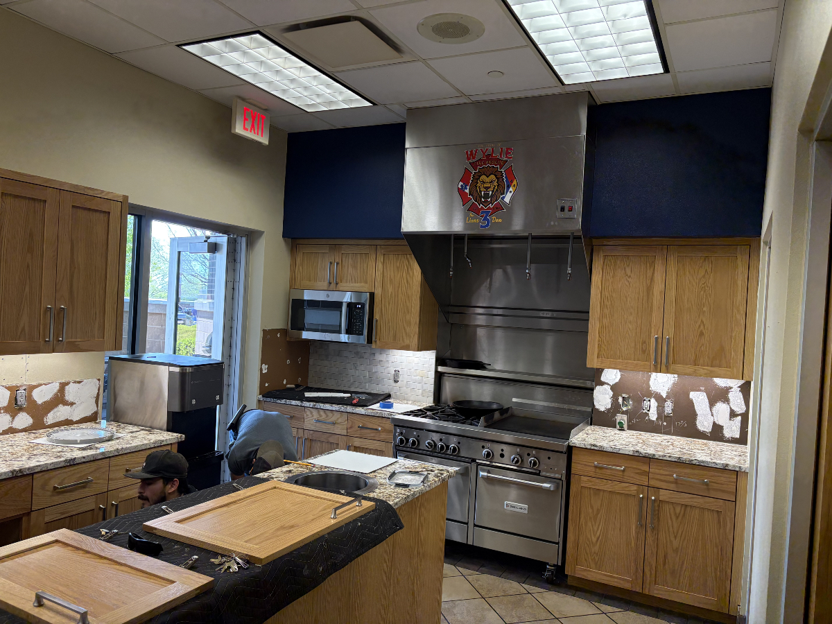 Commercial kitchen undergoing renovations with cabinets removed.
