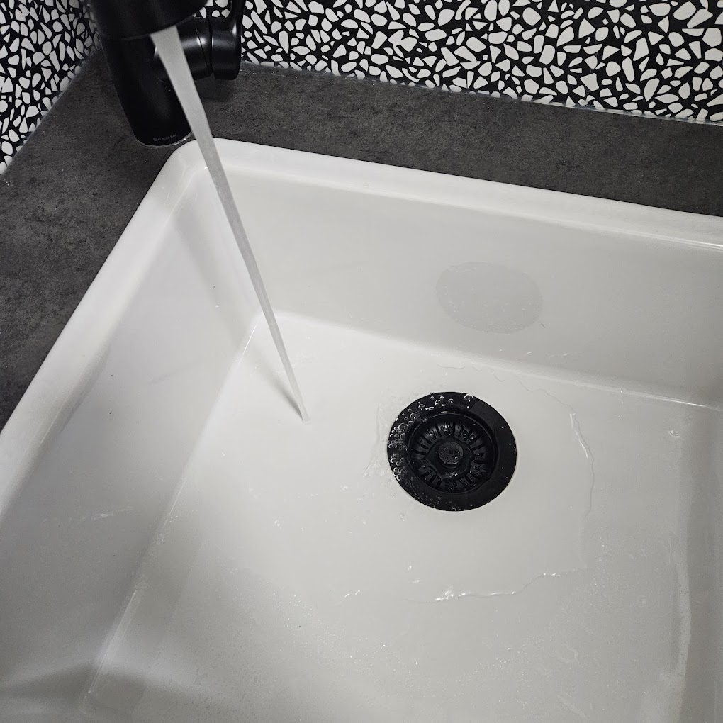 Plumber installs a drain system under a sink in Allen, TX.