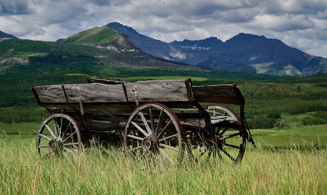 Historical pioneer wagon crossing a rugged mountain ridge - mountain pass frontier crossings