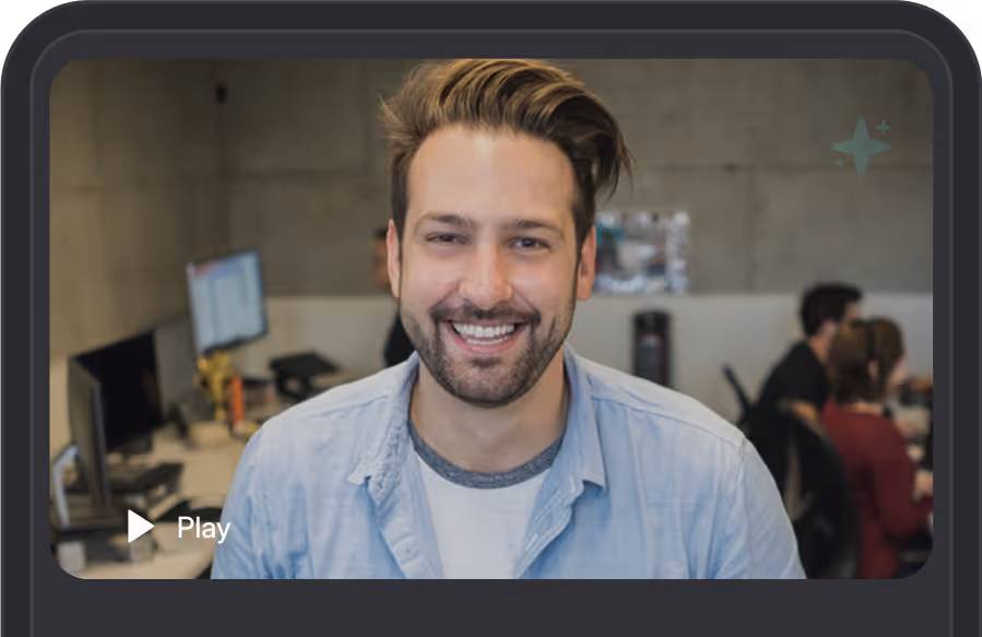 Smiling man in office setting during a video call or interview.