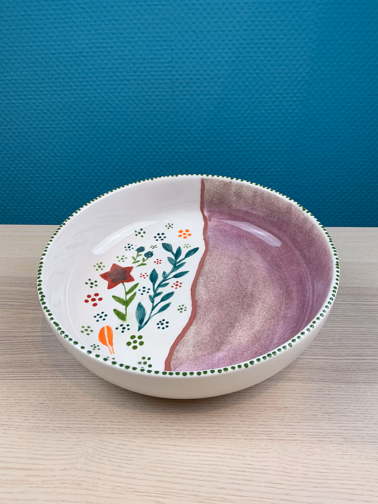 Keramikschale mit halbseitigem Blumenmuster und violettem Farbverlauf.