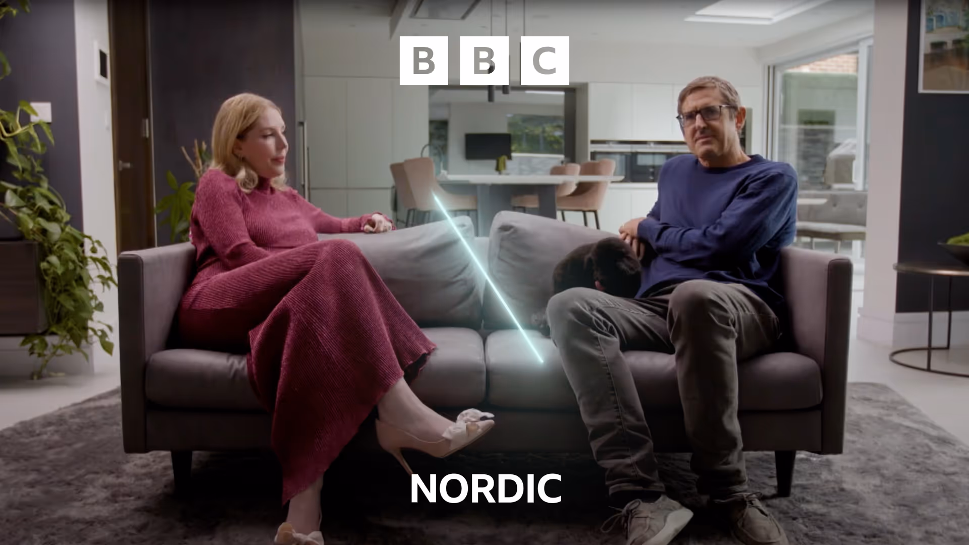 Louis Theroux and Katherine Ryan engage in conversation on a sofa featuring the BBC Nordic branding system