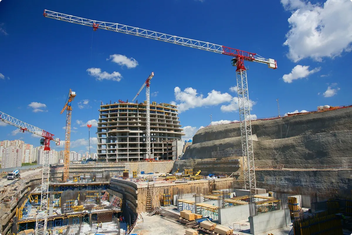 Großbaustelle mit tiefer Baugrube, Baugrubensicherung und Kränen