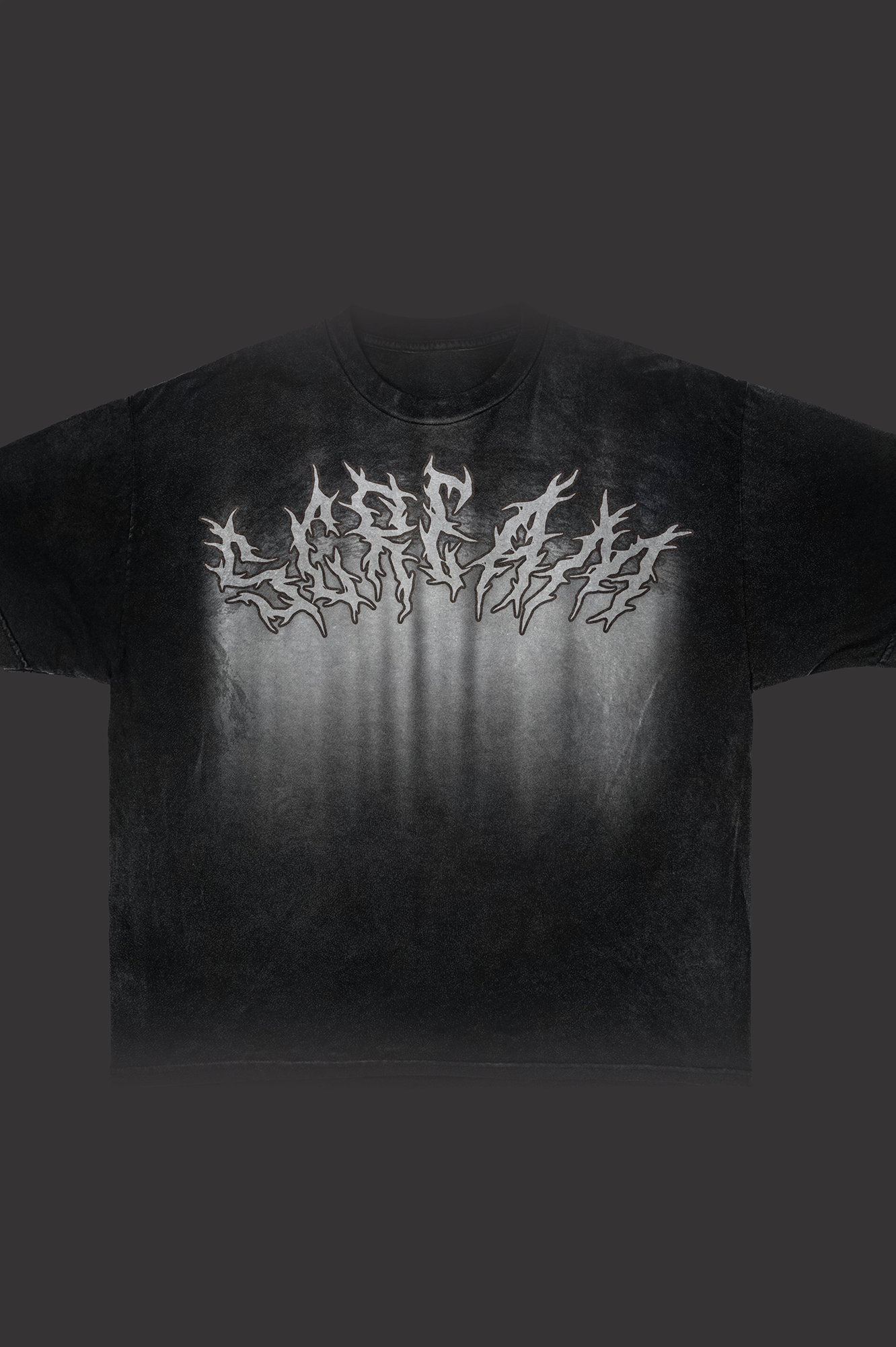 Black t-shirt with ornate white gothic/metal band-style lettering across the chest in elaborate decorative font, photographed against dark background