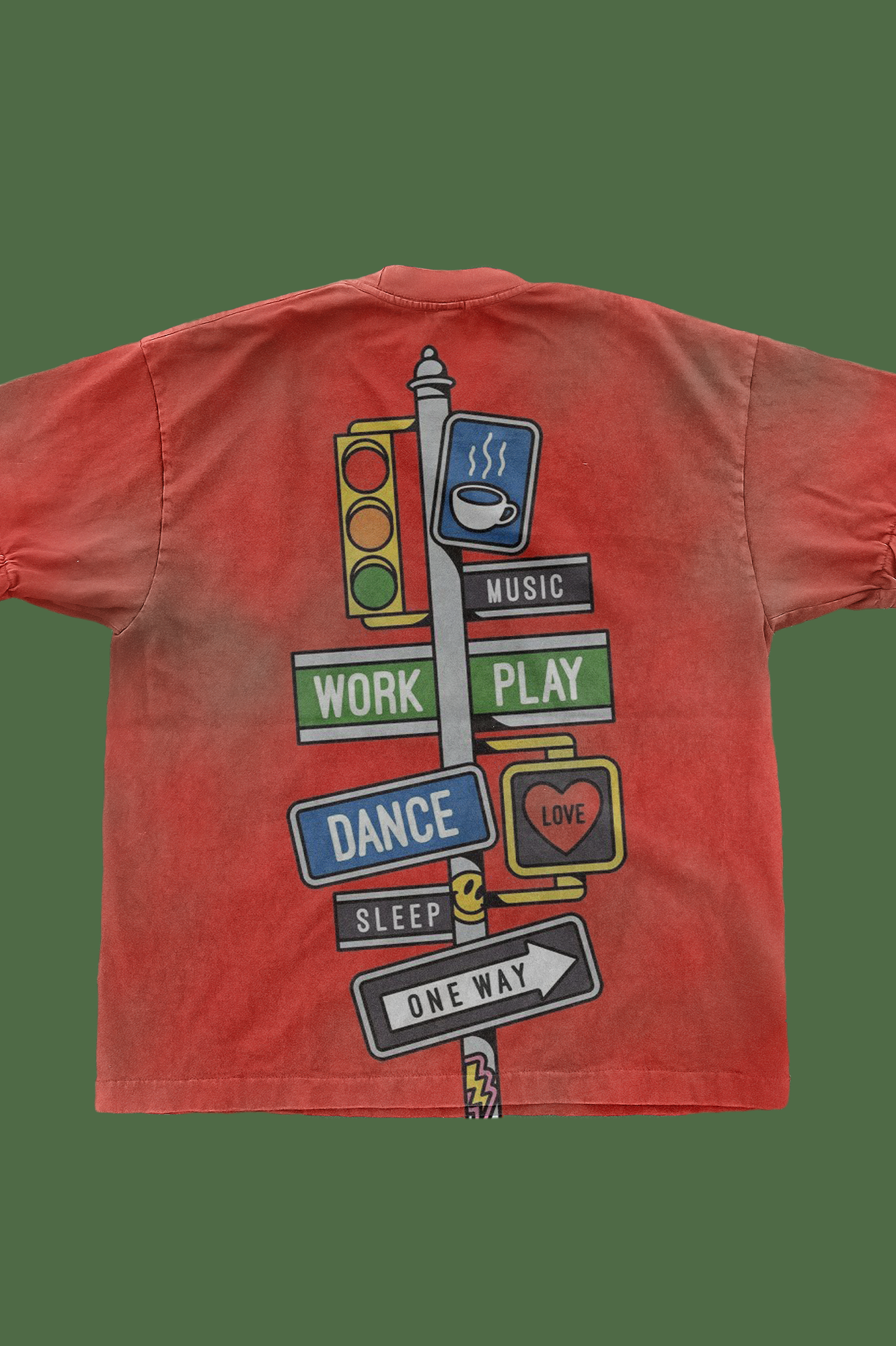 Back view of coral-colored t-shirt featuring a street sign post design with colorful directional signs reading 'WORK', 'PLAY', 'DANCE', 'SLEEP', 'LOVE', 'MUSIC', and 'ONE WAY', along with a traffic light and coffee cup icon, all arranged vertically 