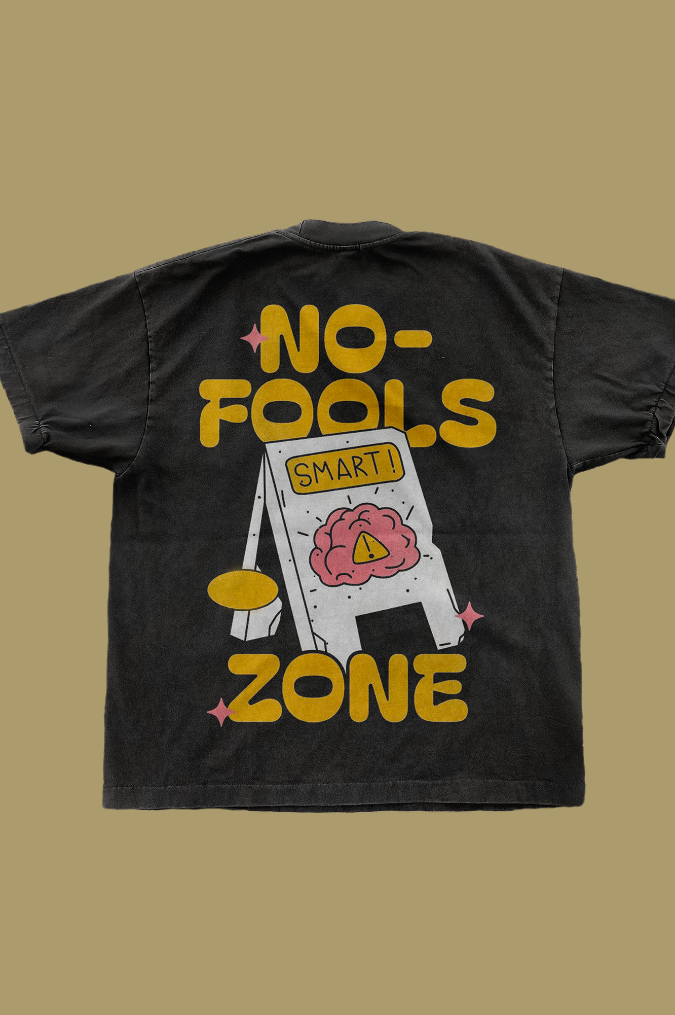 Black t-shirt displaying yellow text 'NO-FOOLS ZONE' with white warning sign graphic containing a pink brain illustration and yellow warning triangle symbol with 'SMART!' text