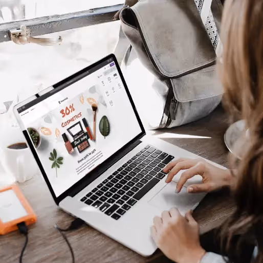 Hands typing on a laptop editing a Black Friday 30% off cosmetics sale responsive email template in an email builder.