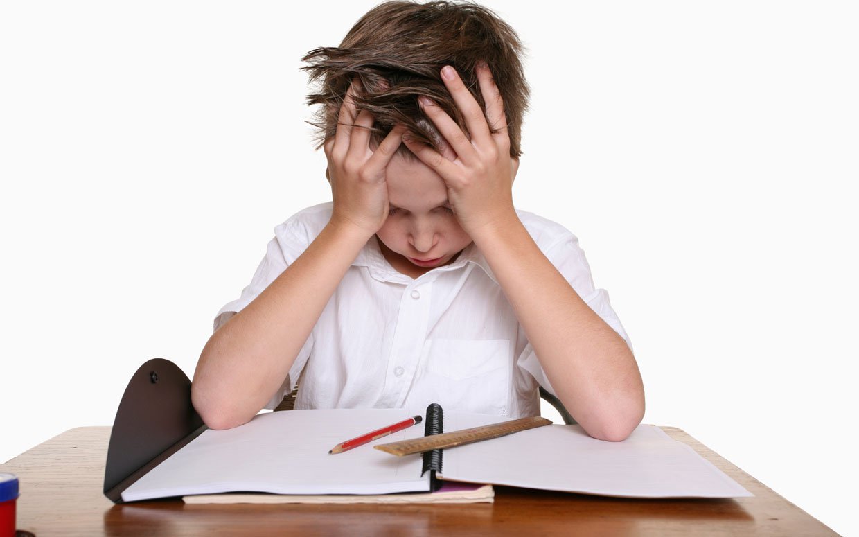 A young boy with his head in his hands