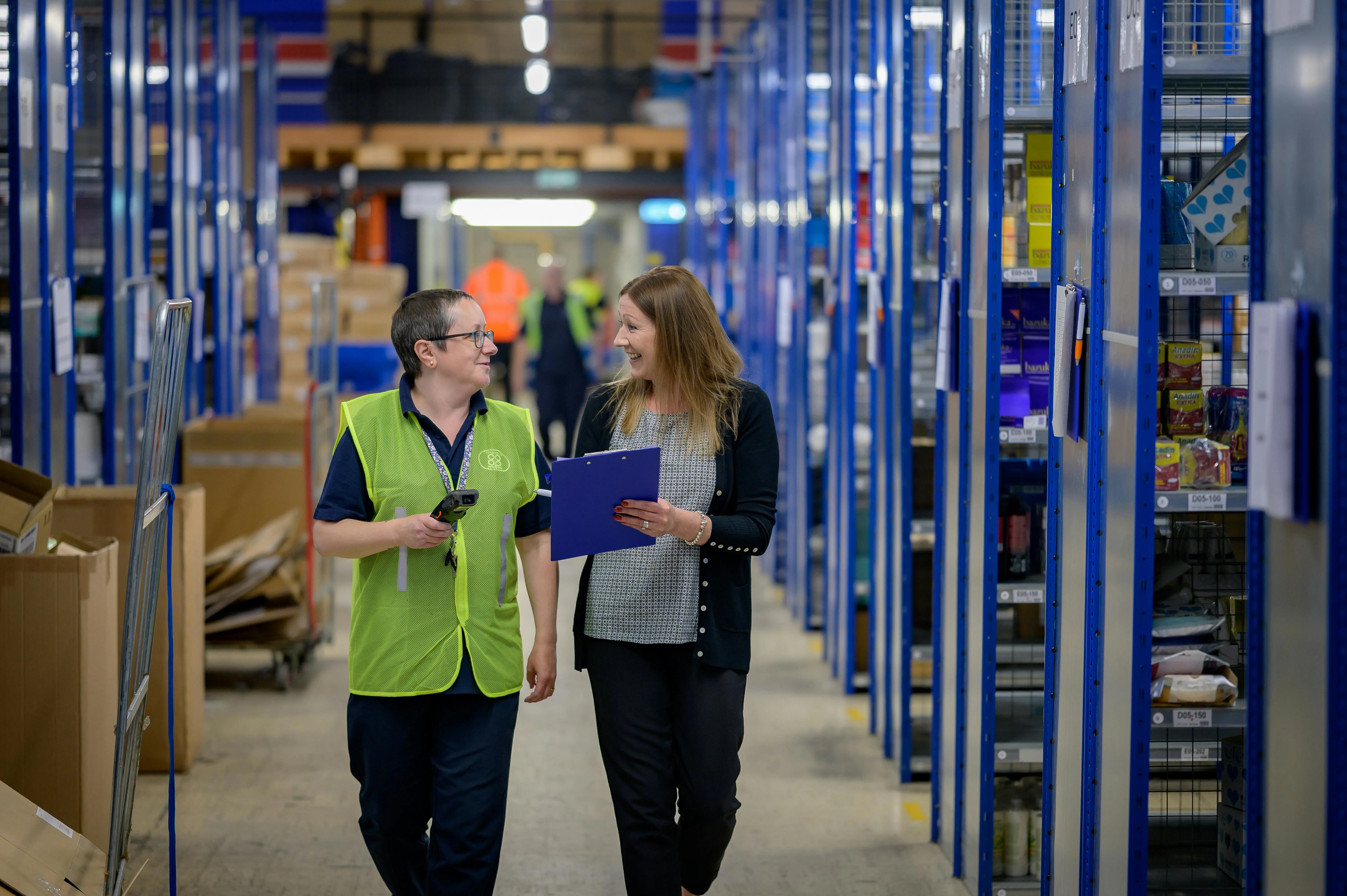 Two women walking through a warehouse together
