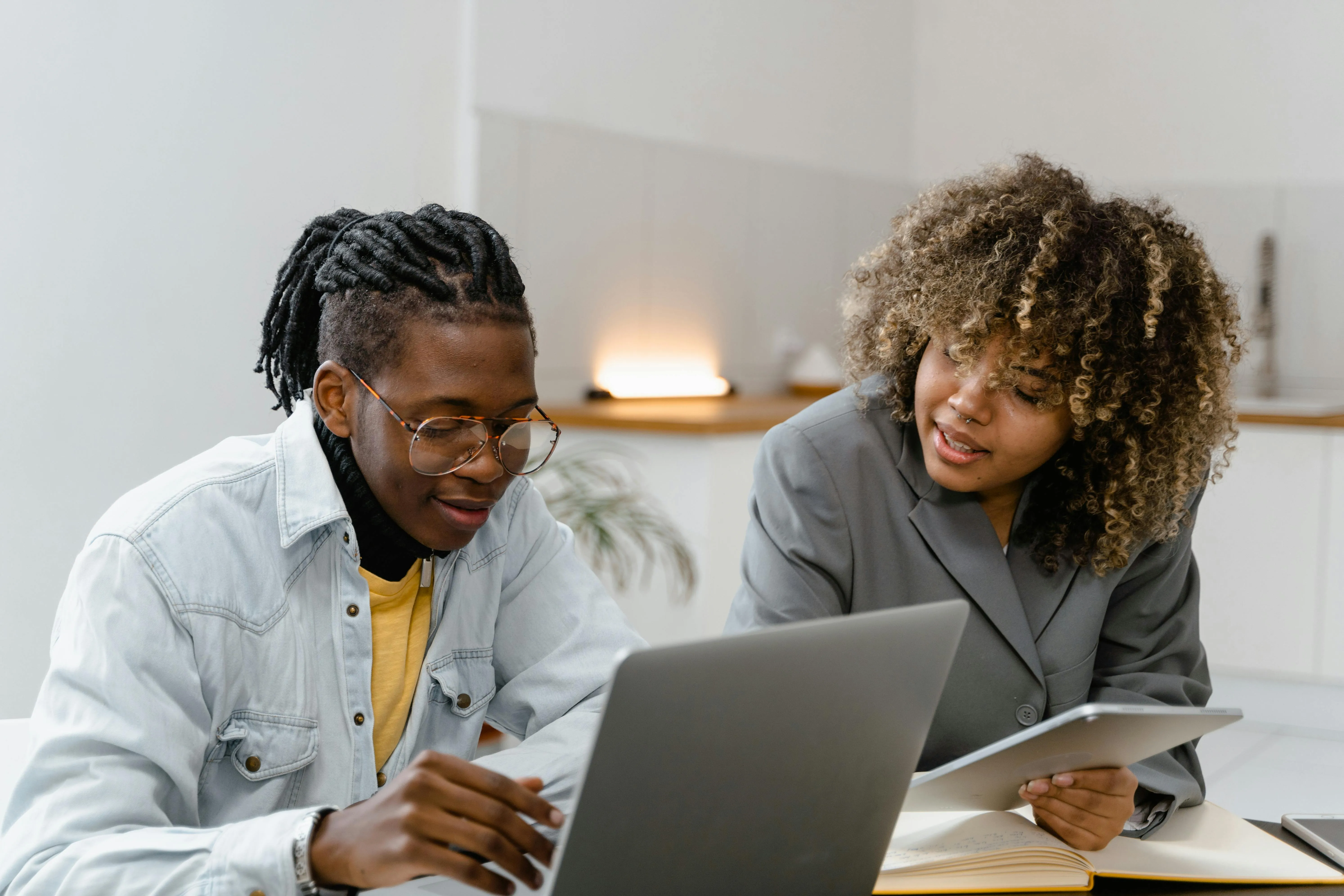 Two woman have a discussion looking at a laptop