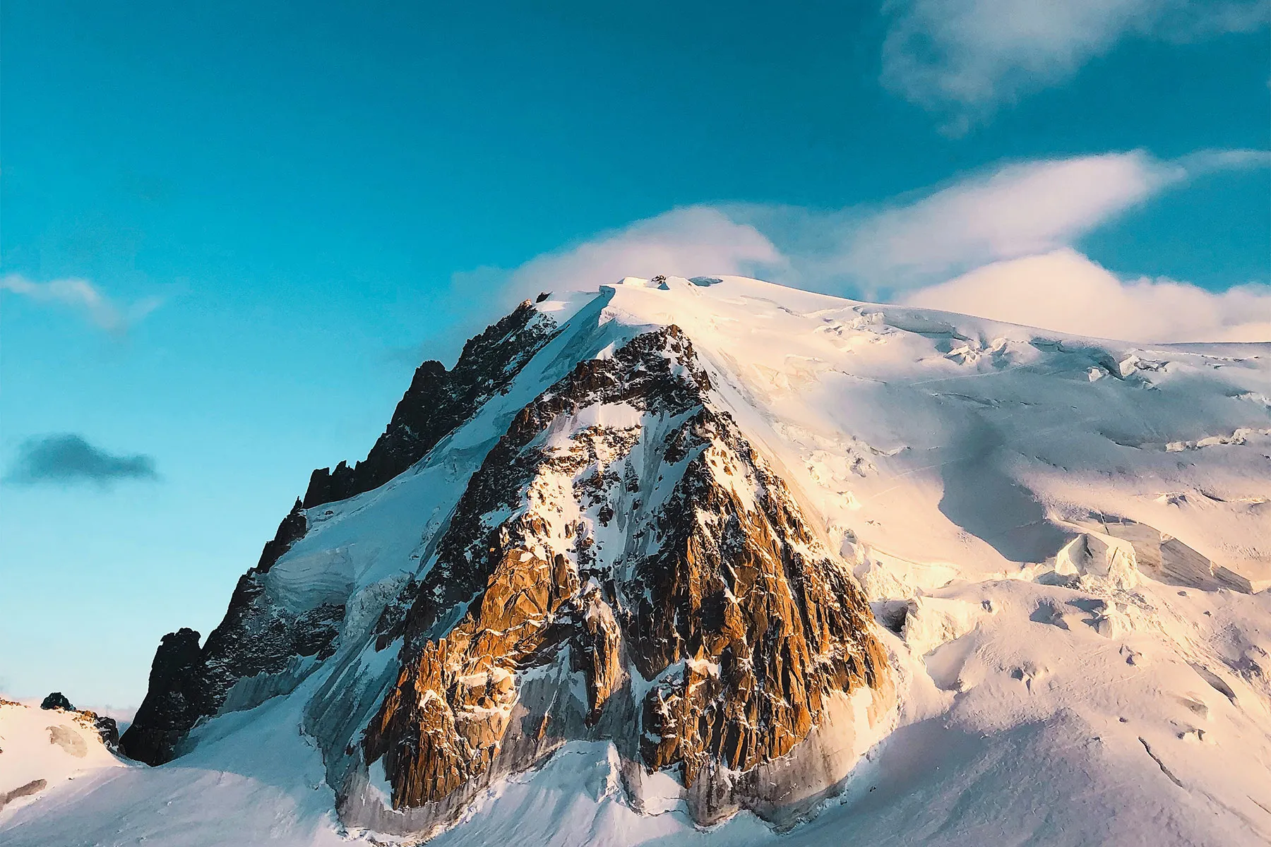 Snow-covered mountain peak under a clear blue sky.