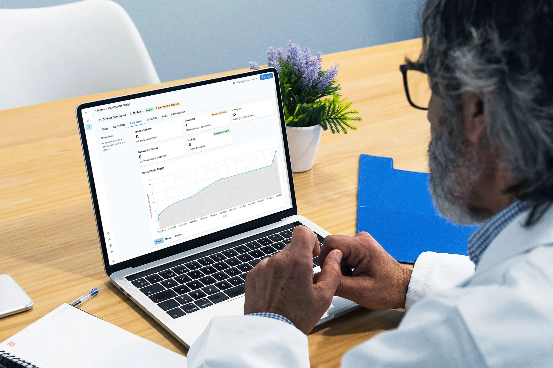 Doctor analyzing data and graphs on a laptop at a desk.