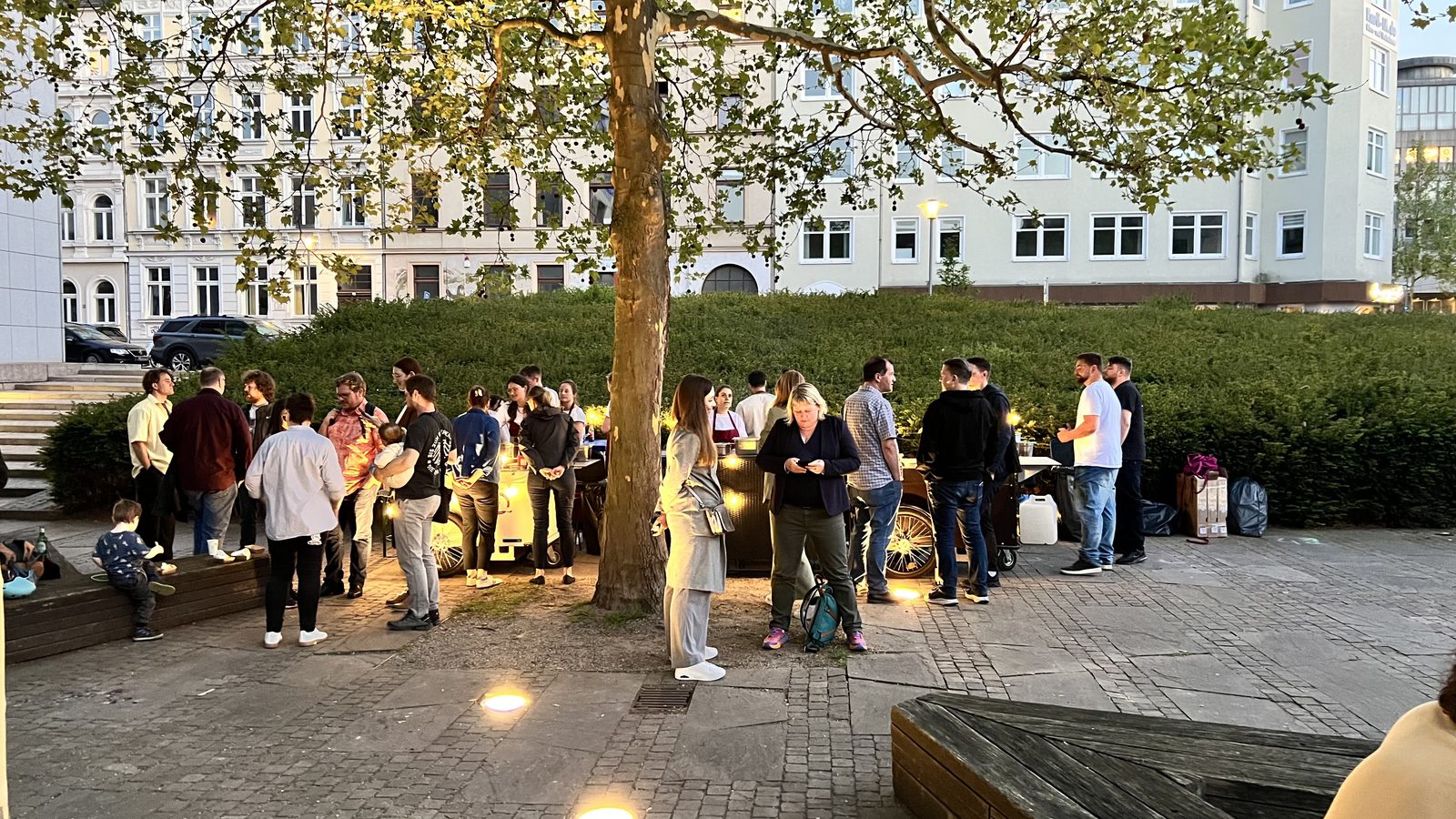 Gäste stehen abends vor dem beleuchteten Waffelstand an