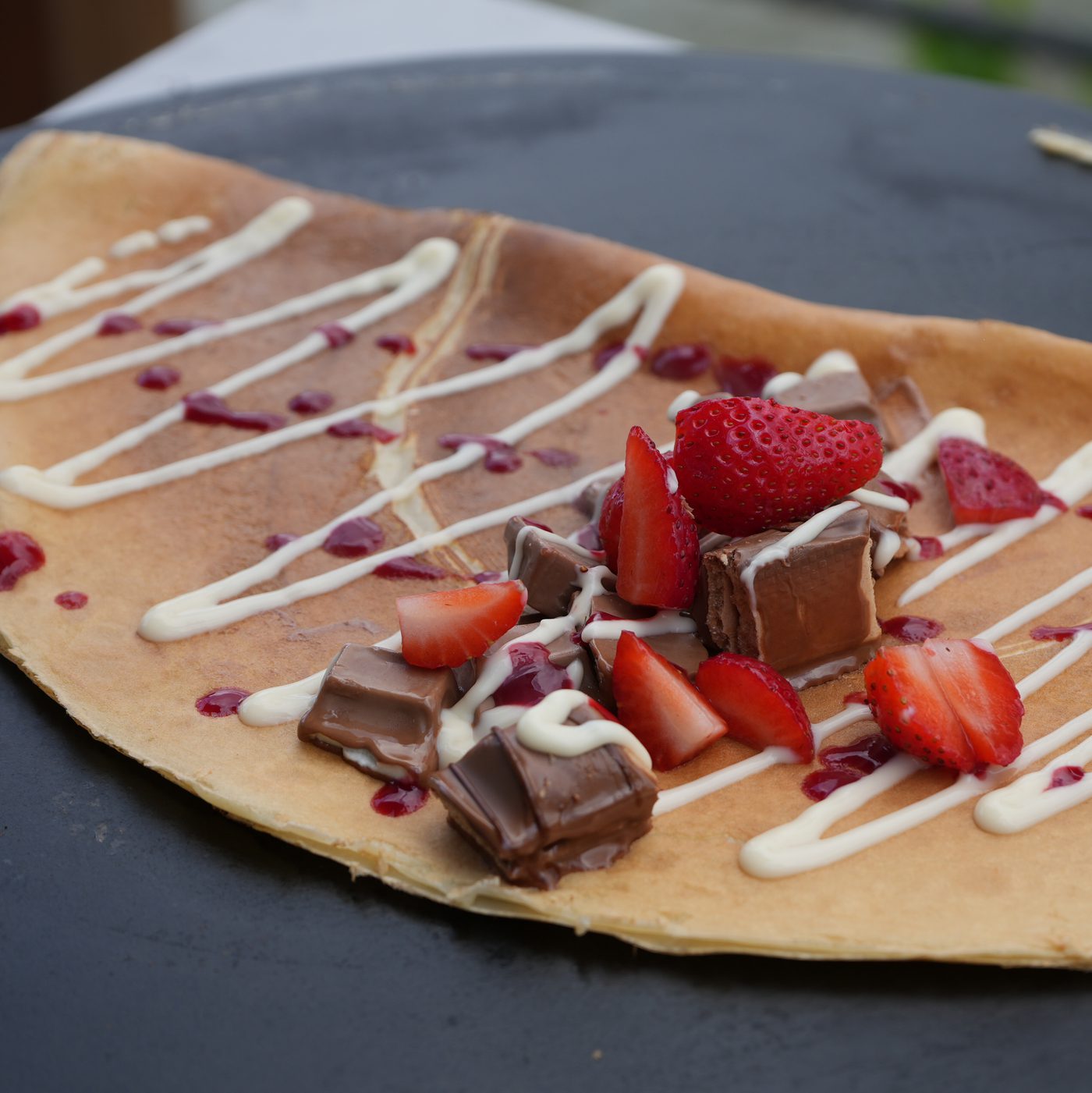 Crêpe mit Nutella, Schokoladenstückchen, Erdbeeren und Sahnestreifen