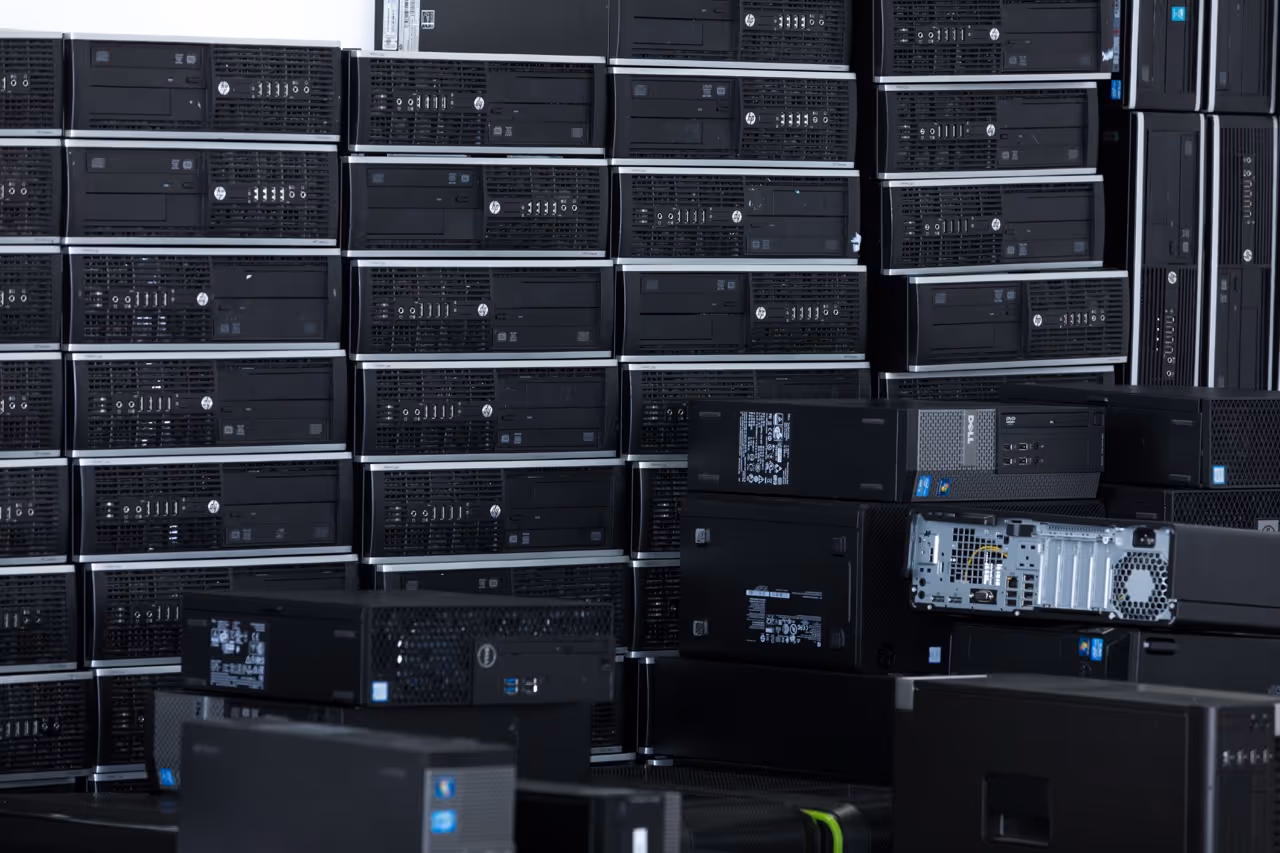 Stacks of desktop computer towers in a storage or recycling area.