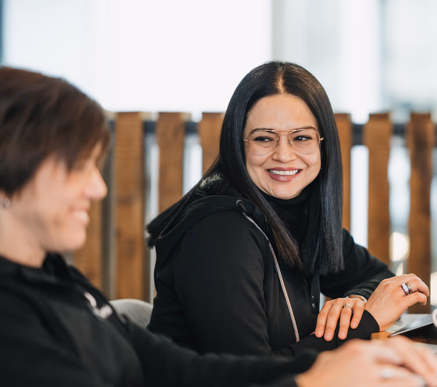 A woman sitting at a table with a laptop computer.