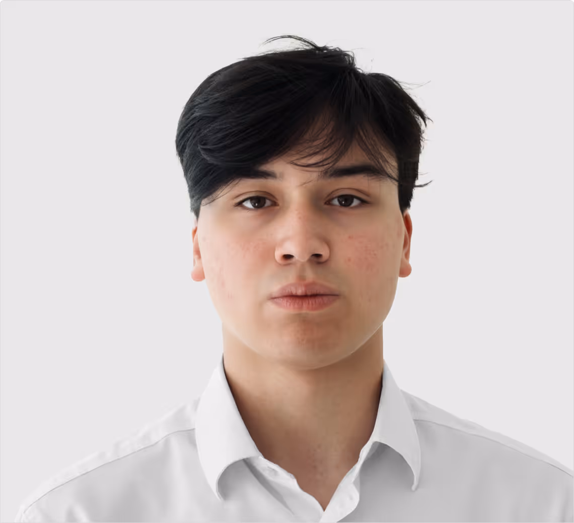 Young man with black hair wearing a white collared shirt against a plain light background.