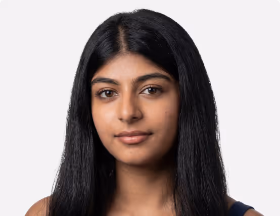 Portrait of a young woman with long black hair and a neutral expression against a plain white background.