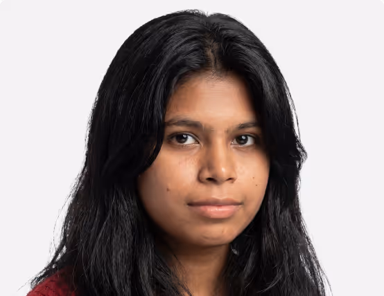Portrait of a young woman with long black hair and a neutral expression against a plain white background.