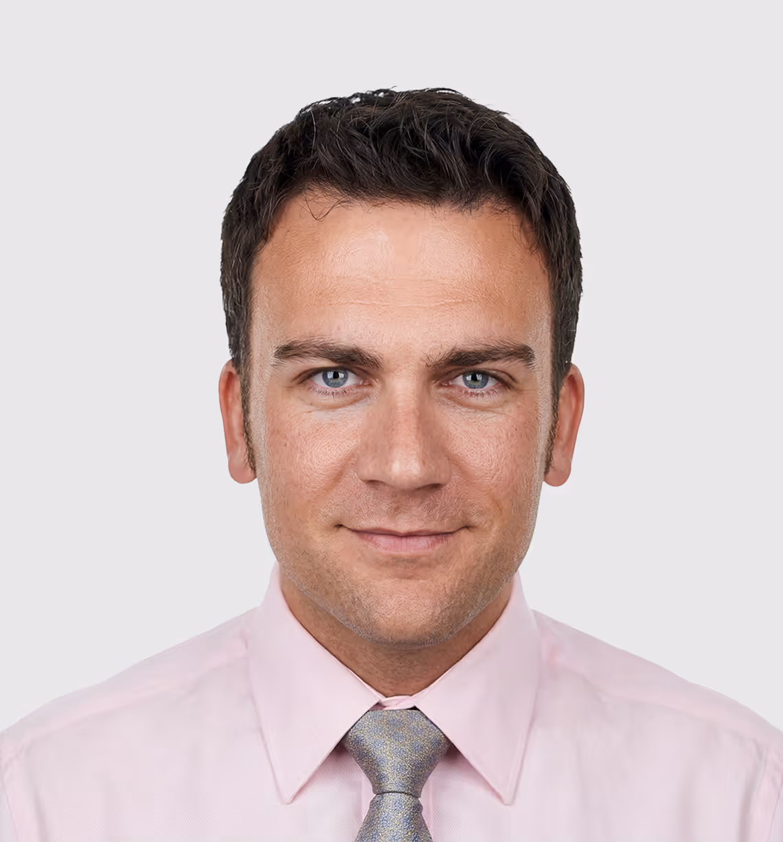 Smiling woman with dark hair pulled back, wearing a gray dress with a white collar and crossing her arms.
