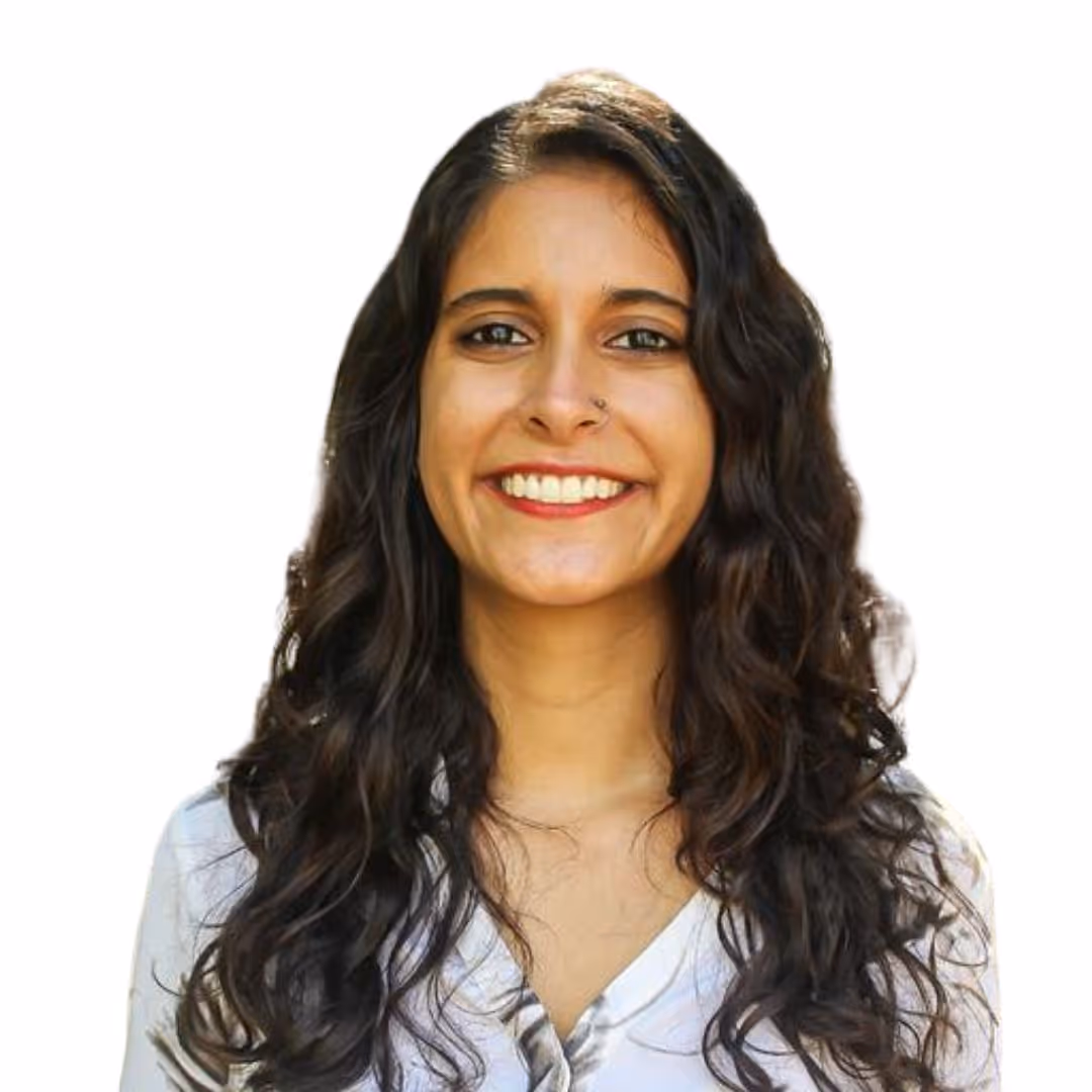 Smiling young woman with short brown hair and tortoiseshell glasses against a white background.