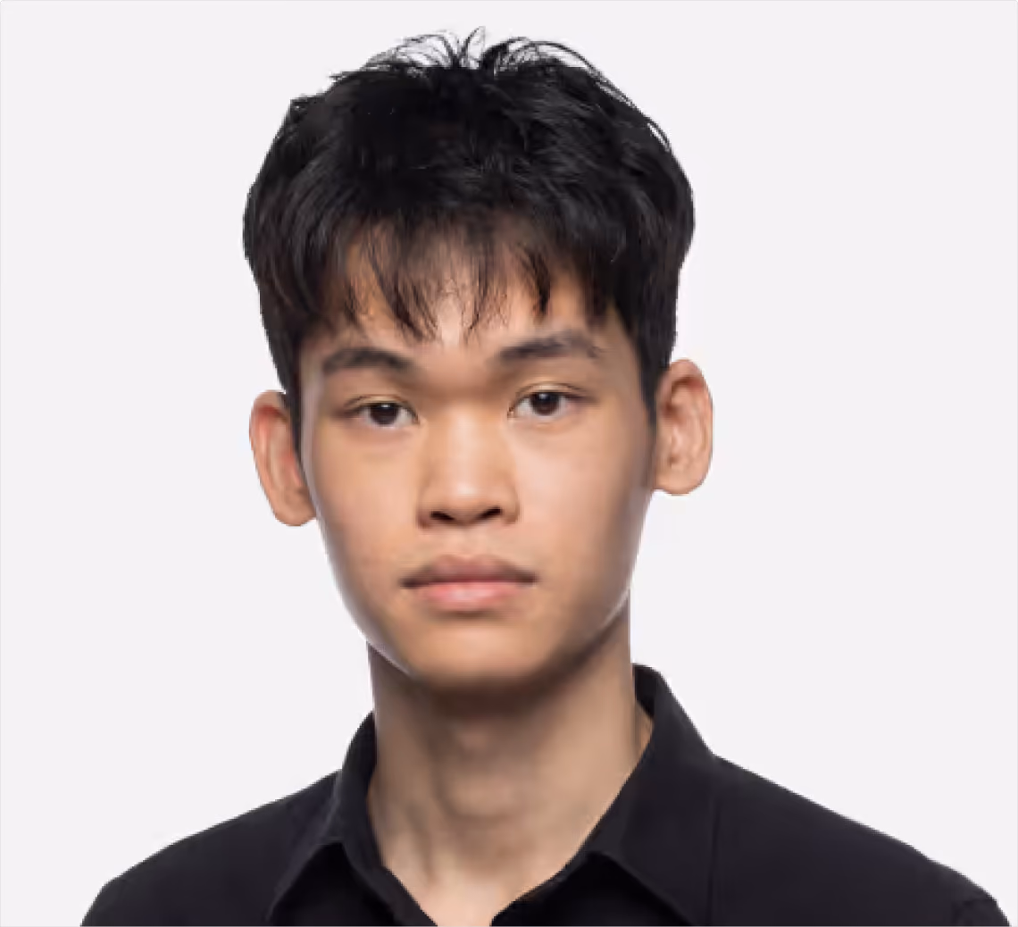 Young man with short dark hair wearing a black collared shirt against a white background.