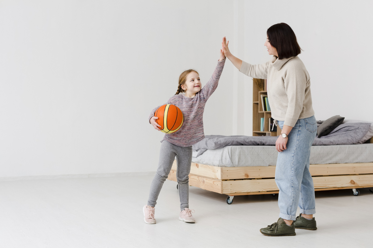 a girl high fiving her mom after playing basketball