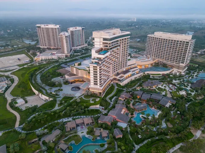 Ảnh chụp một khu nghỉ dưỡng lãng mạn ở Hội An, với hồ bơi ngoài trời và không gian xanh mát, lý tưởng cho các cặp đôi tận hưởng kỳ nghỉ yên bình — resort Hội An cho các cặp đôi.