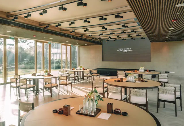 Ảnh chụp một **địa điểm tổ chức networking event tại Hội An** với không gian ngoài trời sang trọng, ánh đèn vàng ấm áp, nhiều người đang trò chuyện và trao đổi danh thiếp trong khung cảnh cổ kính đặc trưng của phố Hội.