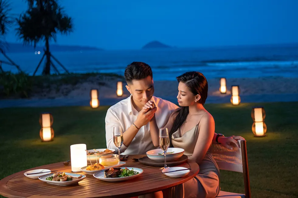 Ảnh chụp một khu nghỉ dưỡng lãng mạn ở Hội An, với hồ bơi ngoài trời và không gian xanh mát, lý tưởng cho các cặp đôi tận hưởng kỳ nghỉ yên bình — resort Hội An cho các cặp đôi.