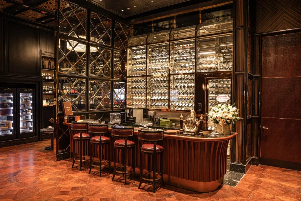 Không gian trưng bày ấm cúng của một cửa hàng rượu tại Hội An, với các kệ gỗ xếp đầy chai rượu thủ công và đặc sản địa phương.