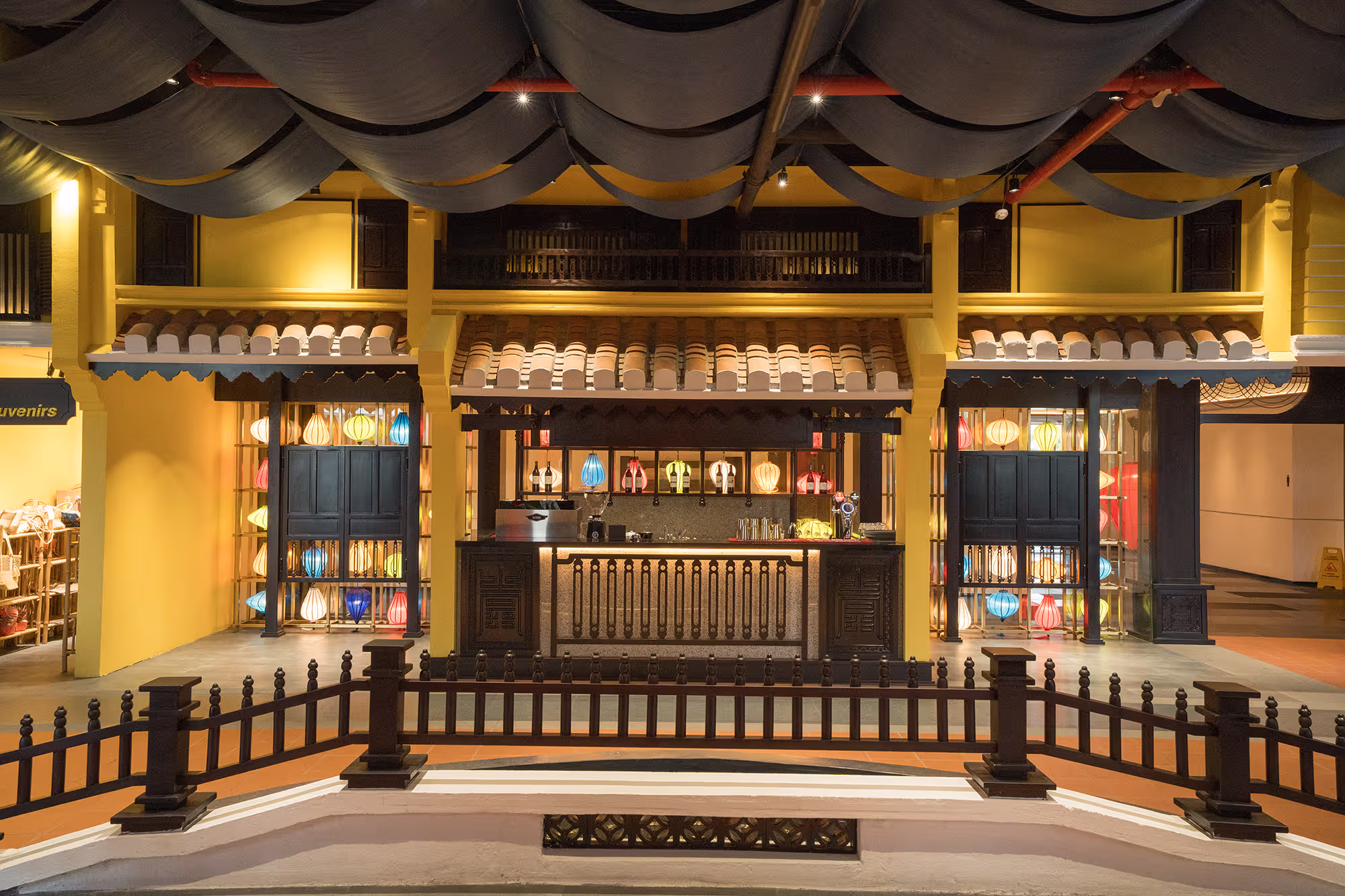 Dark timber bar counter illuminated by warm golden lighting and artisan details