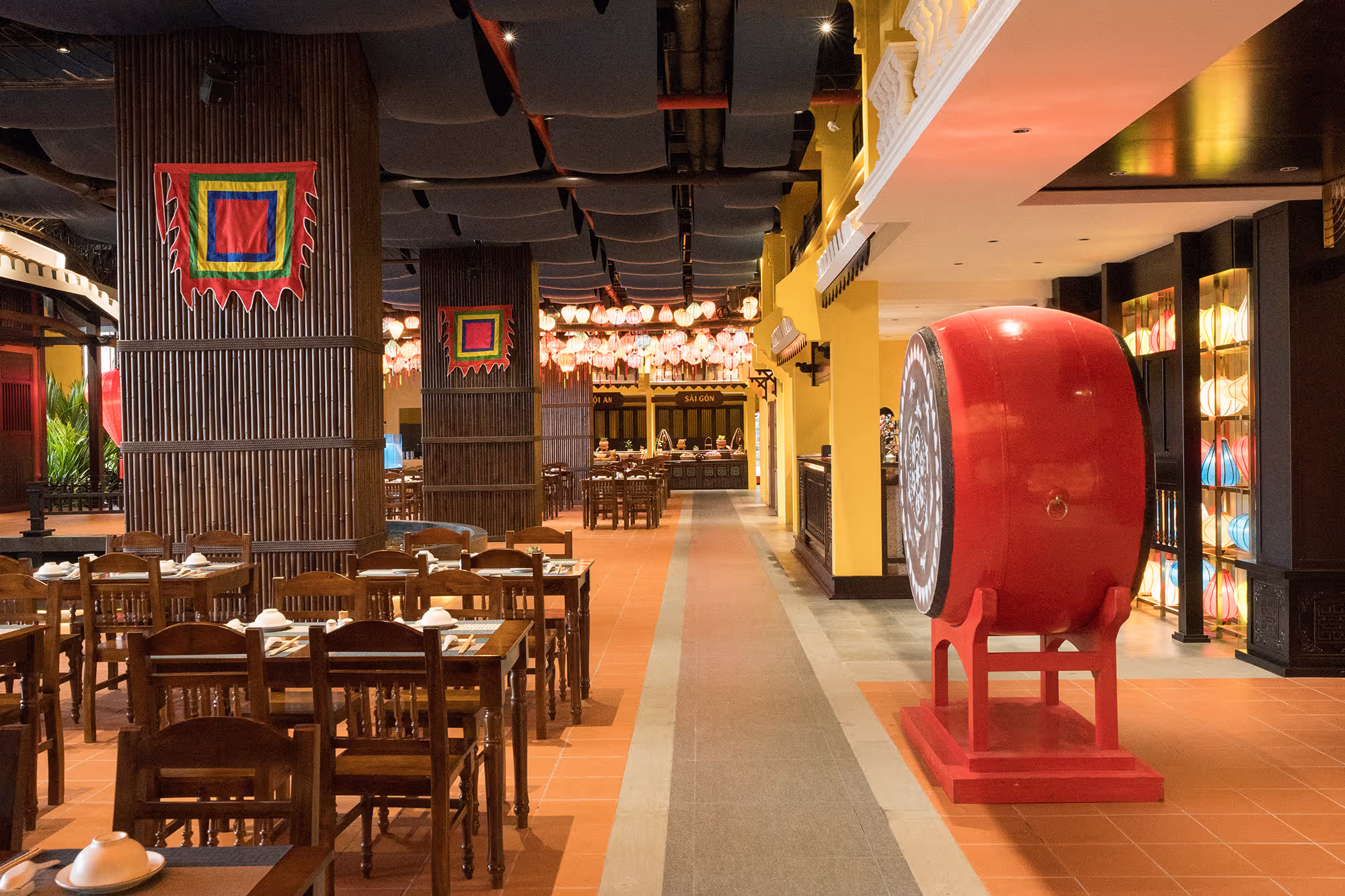 A traditional red drum anchors the lantern-lined dining passage at Hoi An Wonder