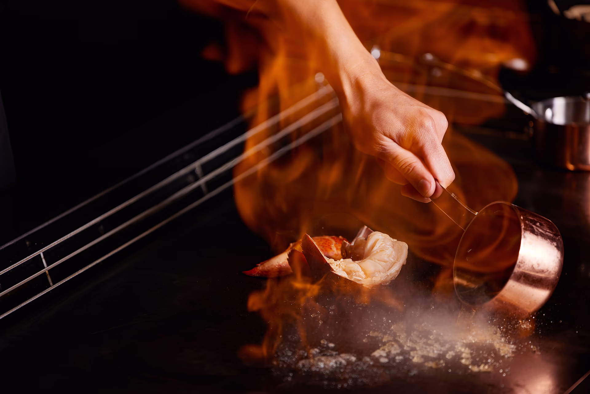 Close-up of a dramatic teppanyaki flame performance over the grill