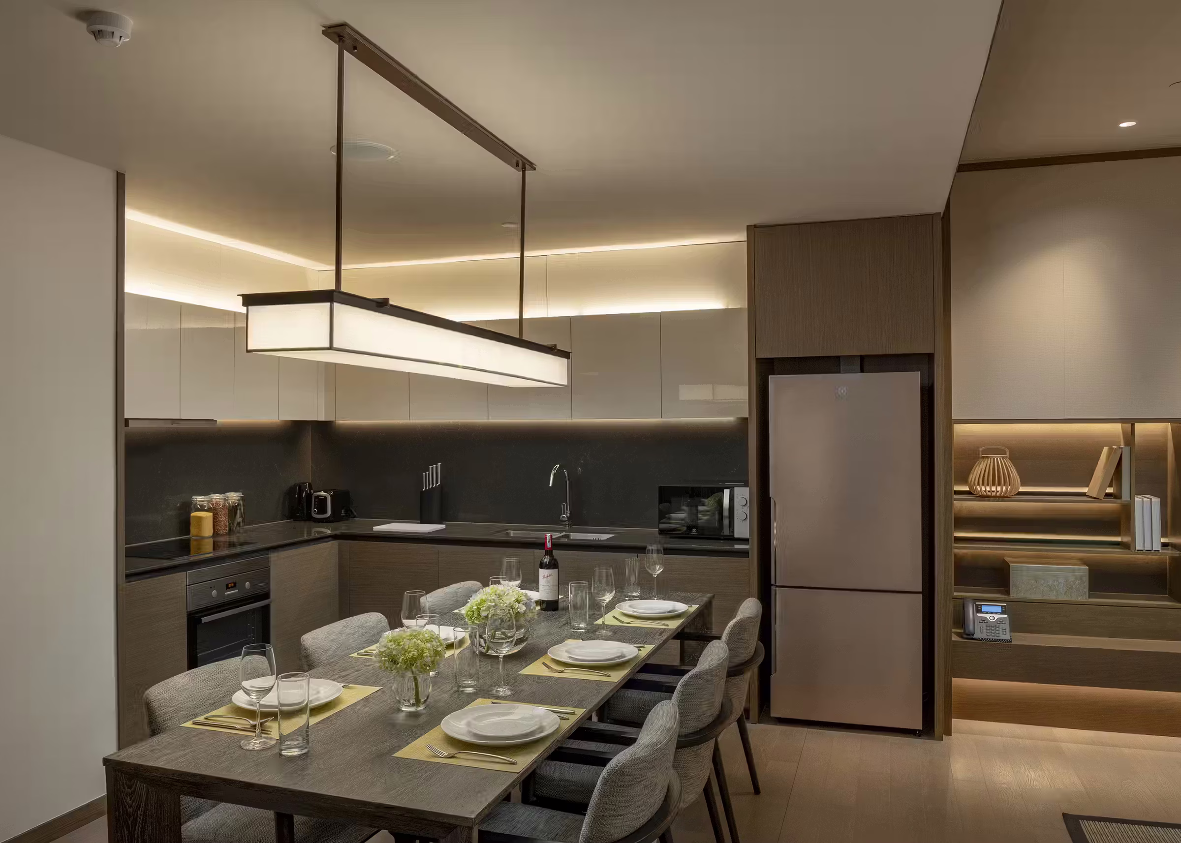 Fully equipped kitchenette with an oven, stove, refrigerator and six-seat dining table in the Three-Bedroom Residence at Hoiana Residences