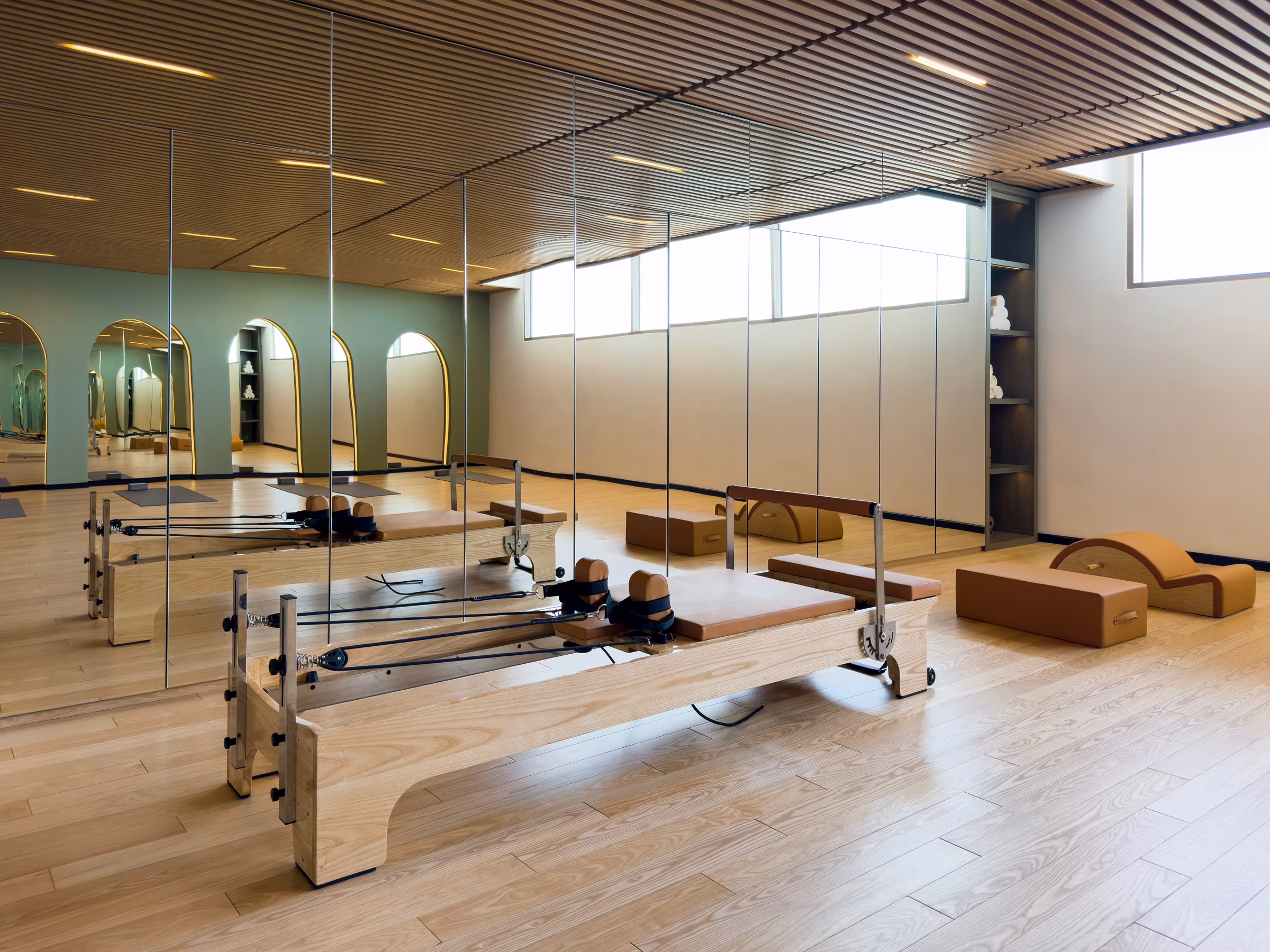 Strength-training area with adjustable benches, free weights and natural light from floor-to-ceiling windows.