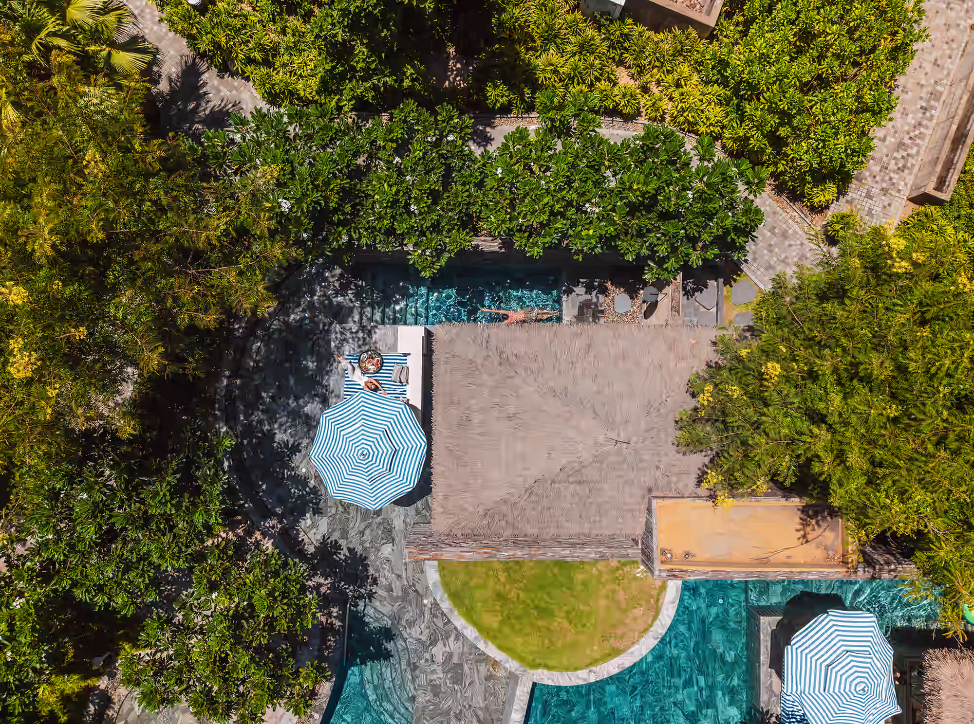 Aerial view of Hide.Out pool houses surrounded by dense tropical gardens and turquoise pools.