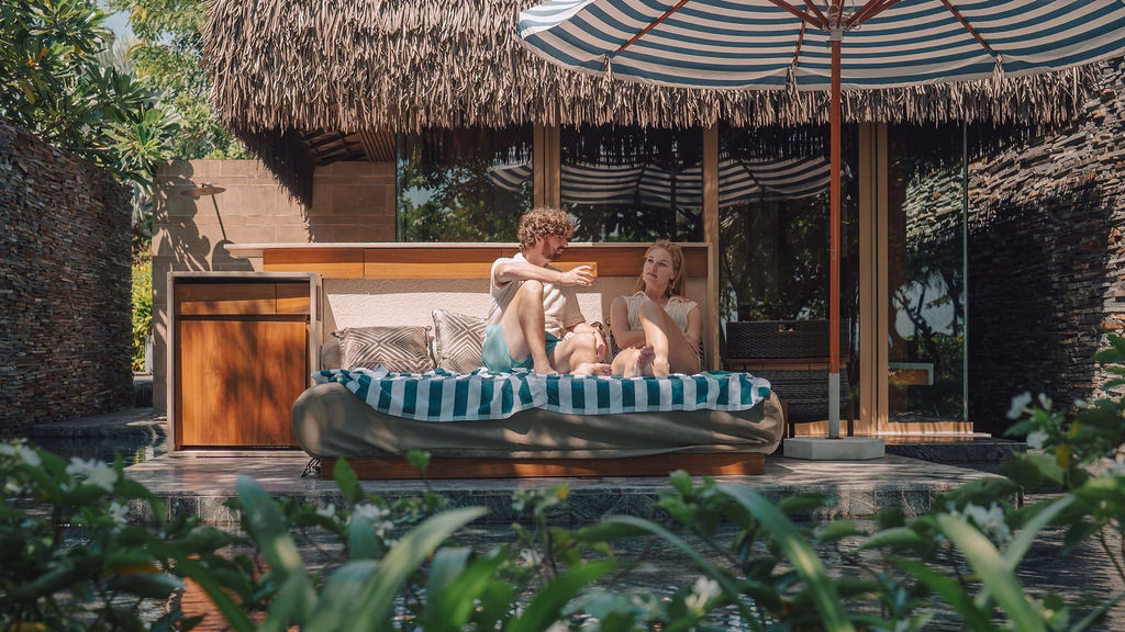 Guests gathering in a private Hide.Out pool house framed by lush tropical foliage.