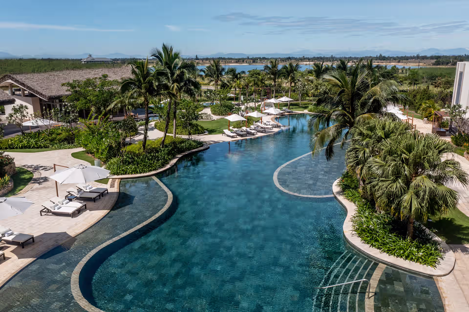 Enchanting free-form waters curve naturally where gentle ripples catch golden sunlight while children's delighted voices float from their own safe haven.