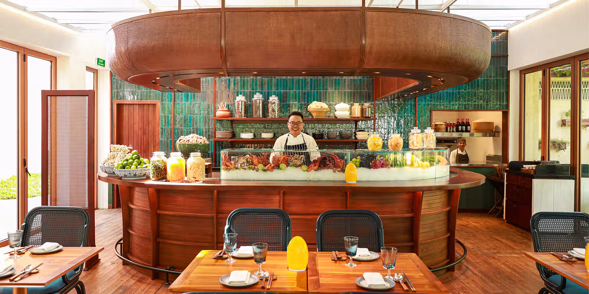 Cham Table Vietnamese seafood restaurant at NOX Beach Club, featuring warm timber interiors and a sculptural canopy inspired by a traditional sail